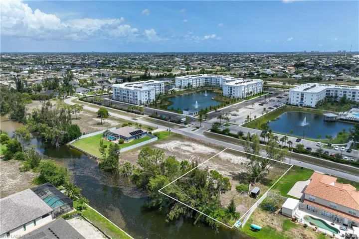 Drone / aerial view of a large body of water and apartment complex / building