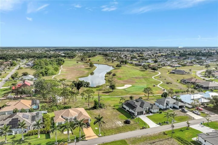 Aerial view of residential area with a nearby body of water and a golf club