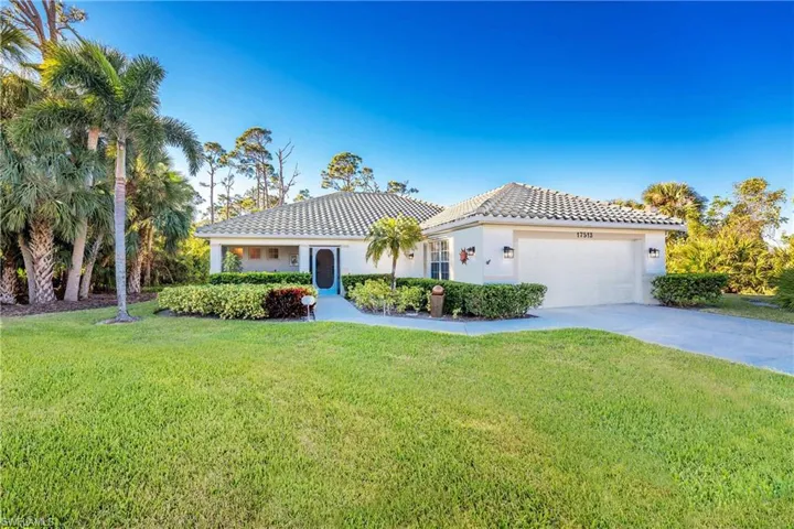 Mediterranean / spanish-style house featuring a front yard and a garage