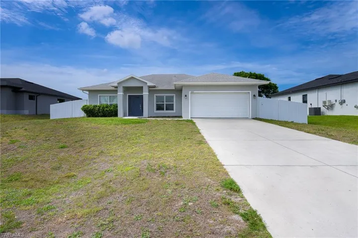 Contemporary single-story residence featuring a light gray exterior and a dark gray entry door