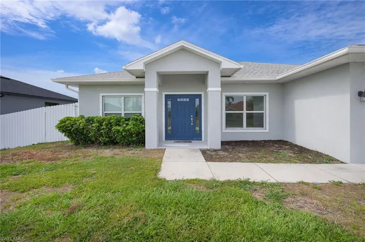 Contemporary single-story residence with a gray stucco exterior and a blue entry door