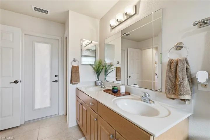 Bathroom featuring double vanity and light tile patterned floors