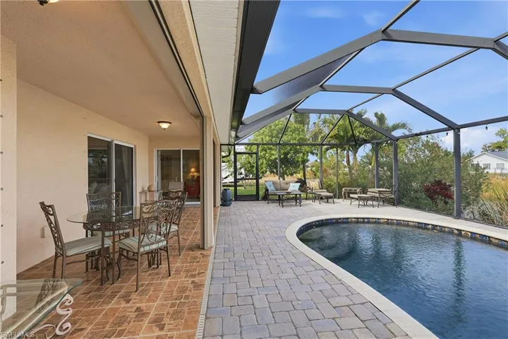 Outdoor pool featuring a patio, a sunroom, a lanai, and outdoor dining space