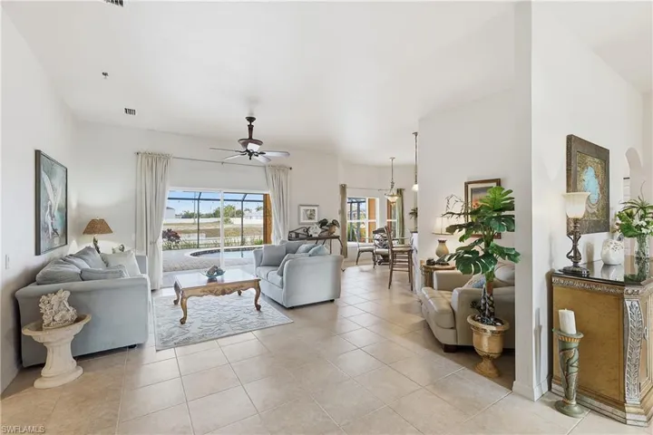 Living room with a ceiling fan and light tile patterned floors