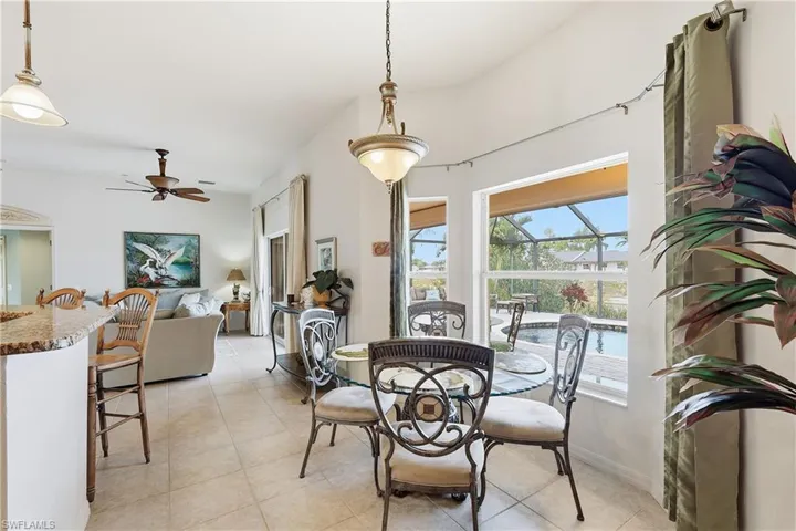 Dining room with a ceiling fan, light tile patterned flooring, and a sunroom