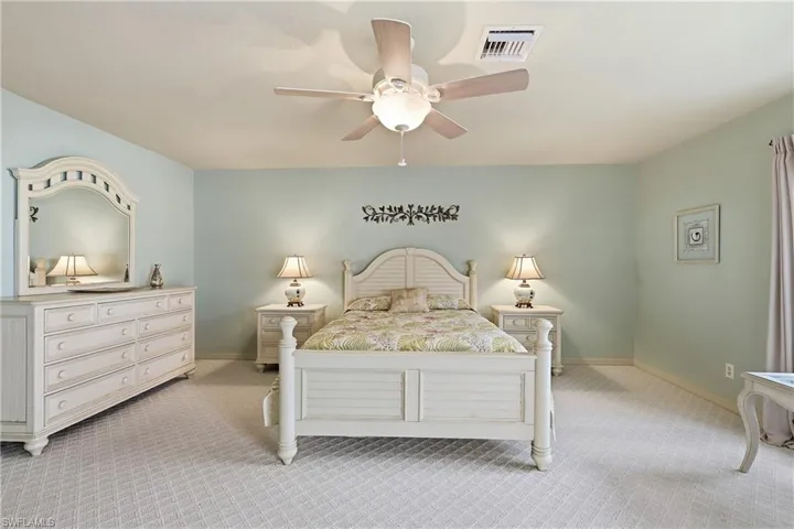 Carpeted bedroom featuring baseboards and ceiling fan