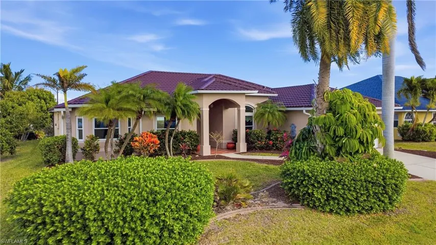 Mediterranean / spanish-style house with stucco siding, a tile roof, and a front yard