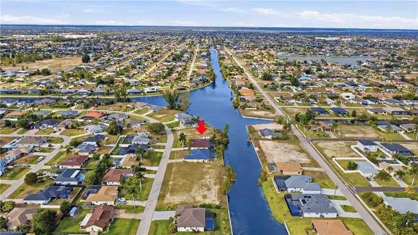 Aerial view of property's location with nearby suburban area and a nearby body of water