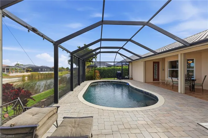 Outdoor pool featuring a sunroom, a lanai, and a patio