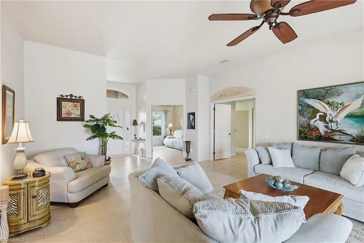 Living room featuring a ceiling fan and light tile patterned floors