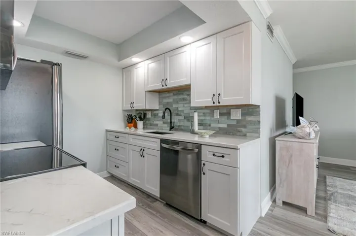 Kitchen featuring a sink, tasteful backsplash, appliances with stainless steel finishes, and light wood finished floors