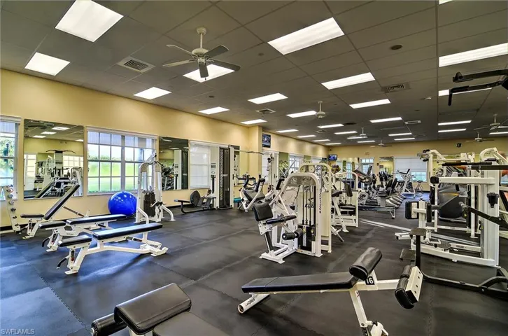 Exercise room with a paneled ceiling and ceiling fan