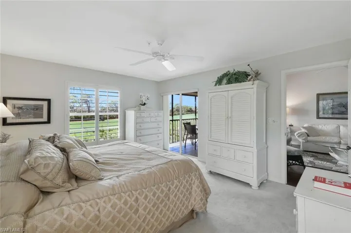 Carpeted bedroom with access to exterior and ceiling fan