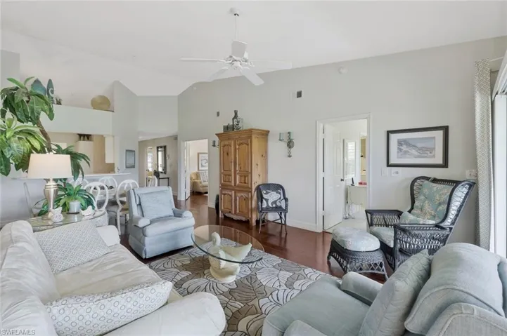 Living room featuring lofted ceiling, dark wood finished floors, and ceiling fan
