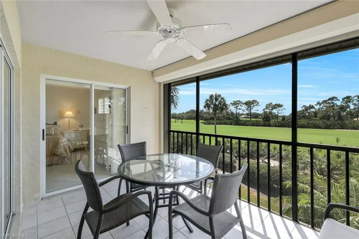 Sunroom with a ceiling fan, golf course view, outdoor dining area, and a balcony