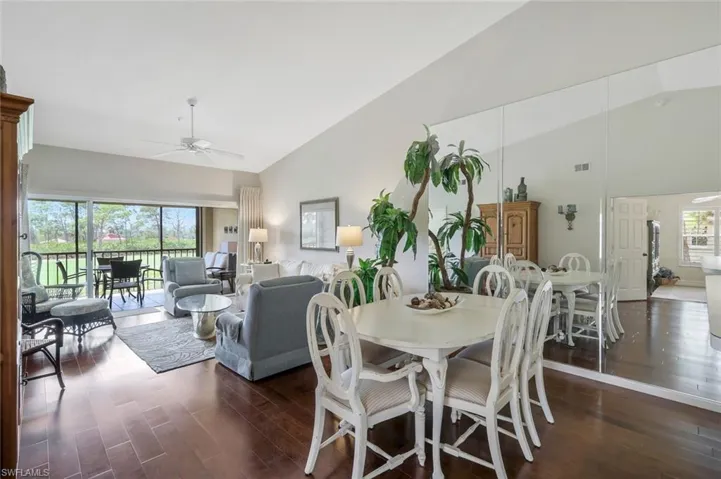 Dining space with ceiling fan, lofted ceiling, and dark wood-type flooring