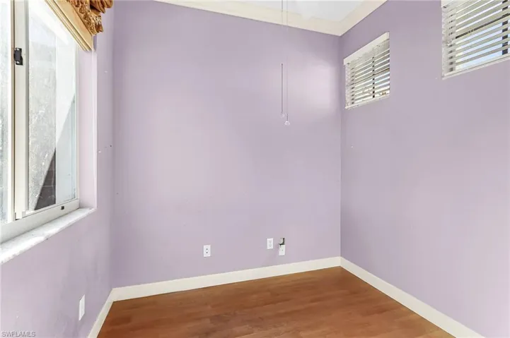 Spare room featuring wood finished floors and crown molding