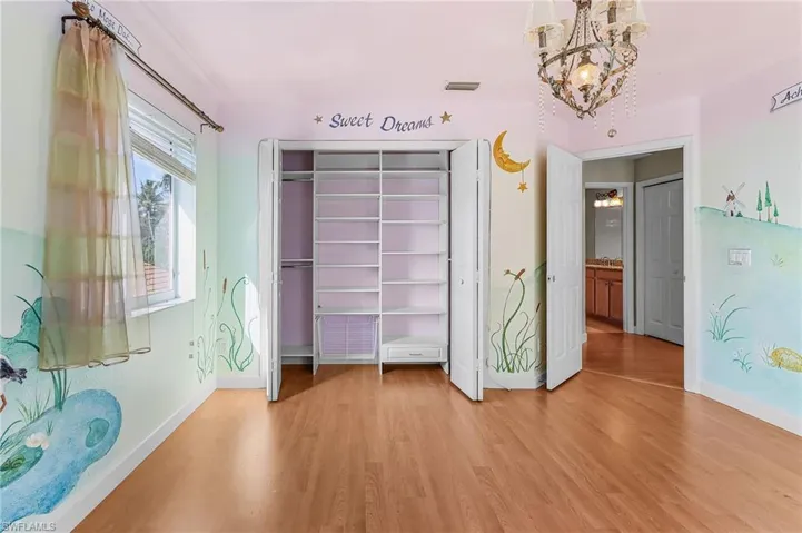 Unfurnished bedroom featuring light wood-type flooring, a chandelier, and a closet