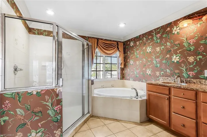 Bathroom with vanity, wallpapered walls, a stall shower, ornamental molding, and a bath