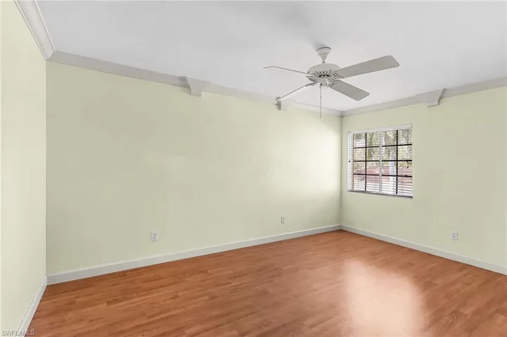 Unfurnished room featuring crown molding, wood finished floors, and ceiling fan