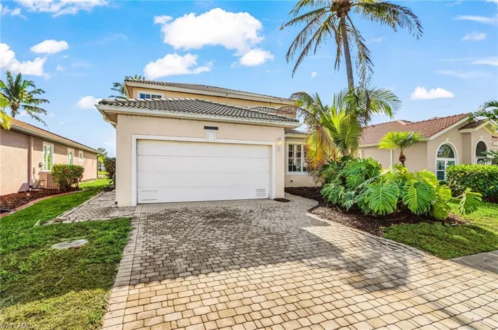 Mediterranean / spanish house featuring decorative driveway, stucco siding, an attached garage, and a tiled roof