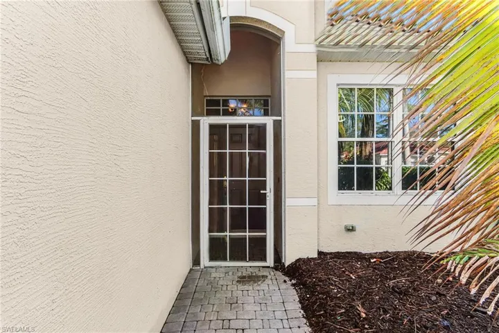 Doorway to property featuring stucco siding