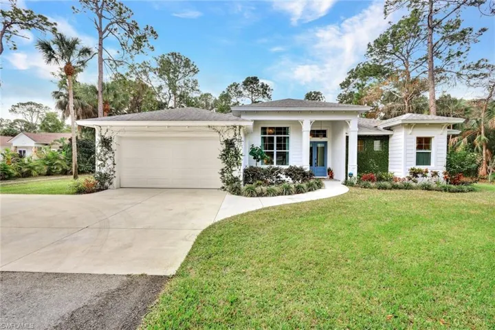 View of front of property featuring concrete driveway, a porch, a front yard, and an attached garage