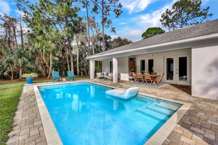 Outdoor pool with french doors, a patio area, and outdoor dining area