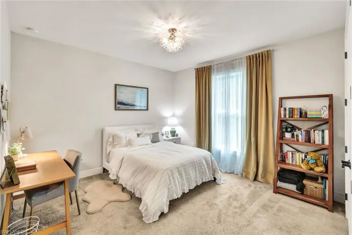Carpeted bedroom with a chandelier