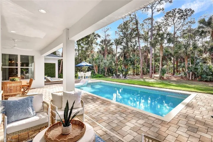Swimming pool with a patio and a yard
