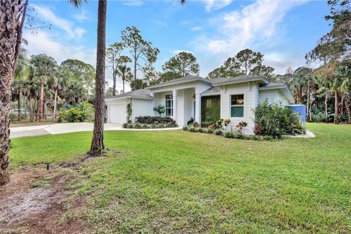 View of front of property with a front lawn, driveway, and an attached garage