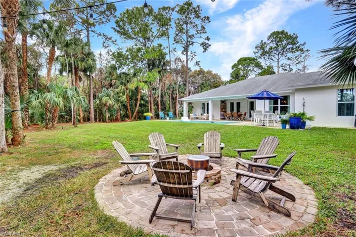 View of grassy yard with a patio and a fire pit