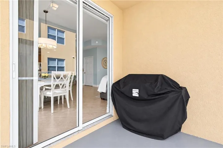 Covered patio featuring a concrete floor, stucco exterior wall, and white-framed glass sliding doors