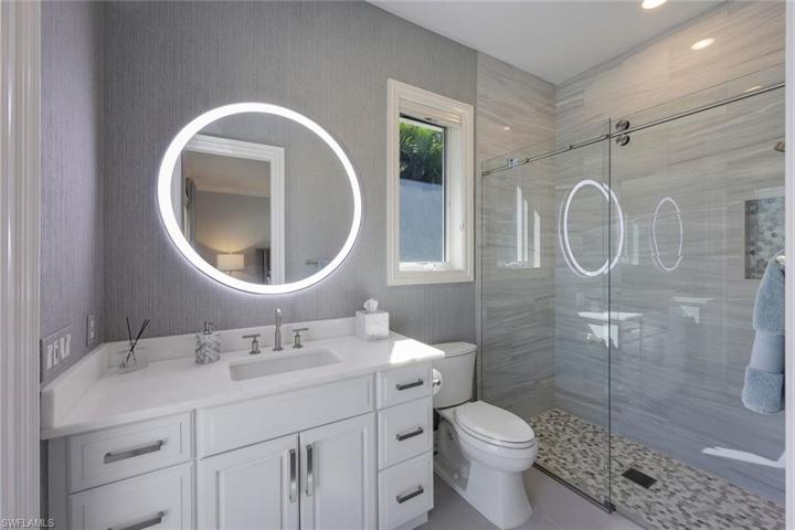 En suite guest bathroom with updated walk-in shower; bathroom accessible to the pool.