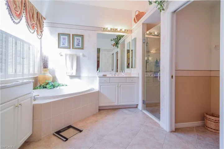 Bathroom with independent shower and bath, tile patterned flooring, and double vanity