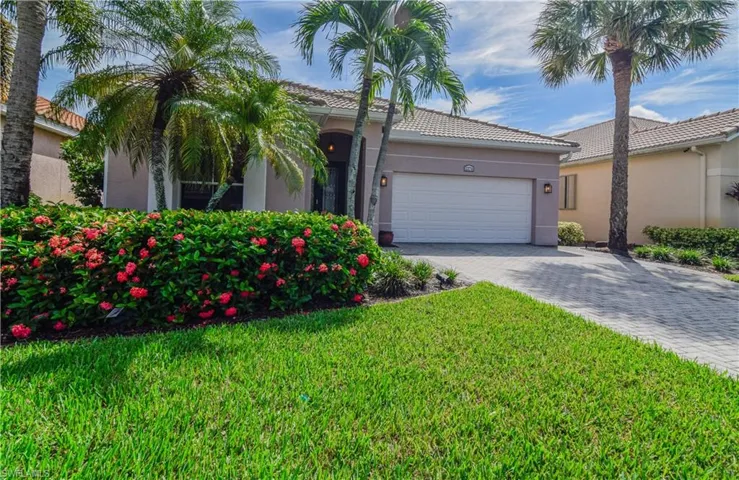 View of front of 2274 Bainmar Dr featuring a 2 Car garage and mature Ixora bushes.
