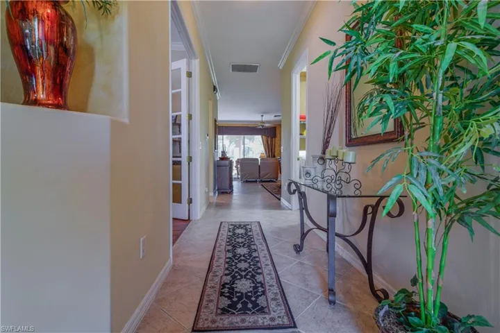 Foyer featuring light tile patterned floors and ornamental molding and display niche.