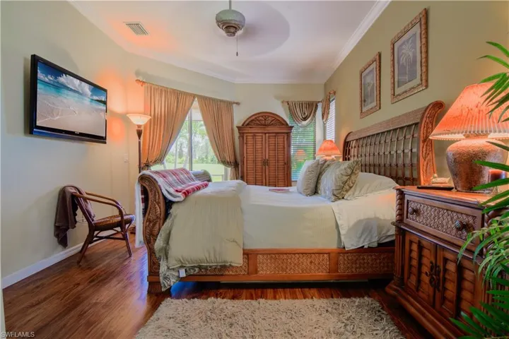 Bedroom with ceiling fan, hardwood / wood-style floors, and crown molding