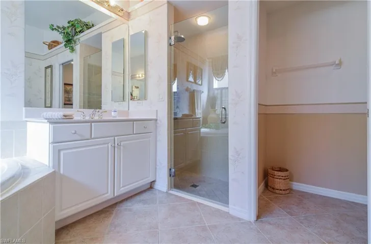 Bathroom featuring separate shower and tub, tile patterned floors, and vanity
