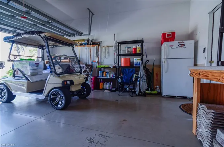 Garage featuring white refrigerator