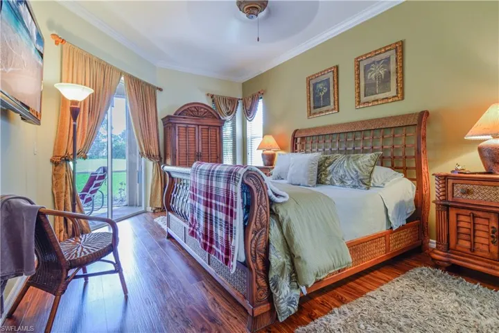 Bedroom with wood-type flooring, access to outside, ornamental molding, and ceiling fan
