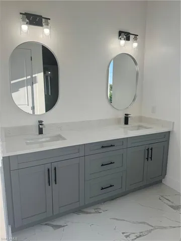 Bathroom with dual vanity and tile flooring