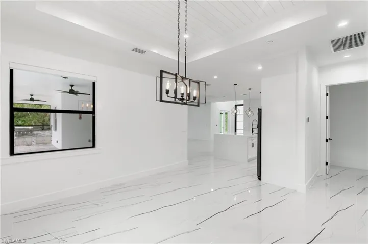 Unfurnished dining area featuring ceiling fan, a tray ceiling, and wooden ceiling