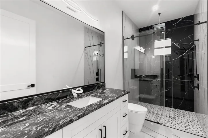 Bathroom with walk in shower, vanity, and toilet