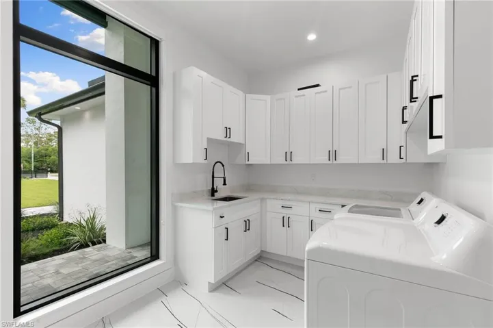 Laundry room featuring cabinets, sink, independent washer and dryer, and plenty of natural light