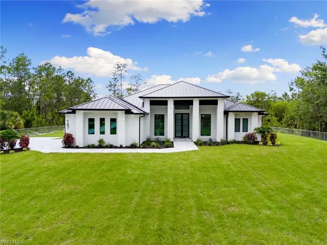 Back of property with a lawn