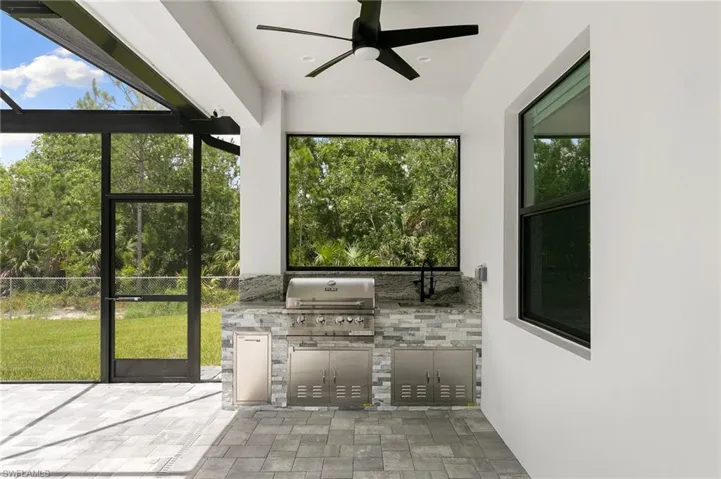 View of patio featuring area for grilling, ceiling fan, and a grill