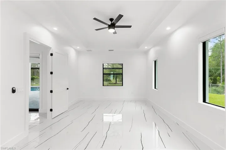 Spare room featuring a raised ceiling, crown molding, and ceiling fan