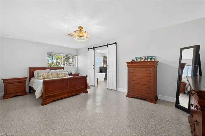 Bedroom featuring a barn door and speckled floor