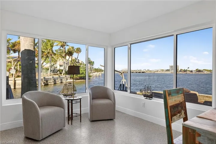 Sunroom / solarium featuring speckle patterned floor and a water view